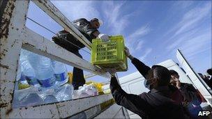 A man supplies water to refugees who fled Libya at a refugee camp at the international Airport of Djerba