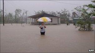 March 8, 2011 woman in floodwater during heavy rain in Cardwell, in the far north of Australia"s Queensland.