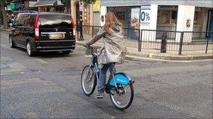 Woman riding a hire bike in London