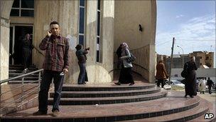 Libyans stand outside a bank in Tripoli, Libya, Thursday March 10, 2011