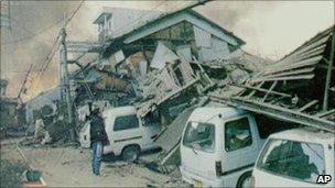 A man looks at a collapsed house in Kobe, Japan, after the 1995 quake