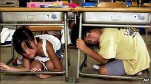 File image of Japanese children taking shelter under their desks during an earthquake drill