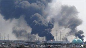 Smoke billows from fires raging at the port in Tagajo, Miyagi prefecture, 13 March