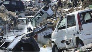 Vehicles swept into a canal by tsunami waves in Tagajo, Miyagi prefecture, 13 March