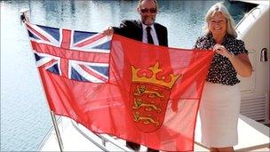 Registrar Piers Baker and Assistant Registrar Debbie Podger with Jersey's "defaced" Red Ensign