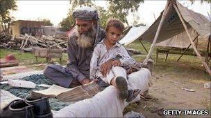 Man and boy in camp after Pakistan flooding