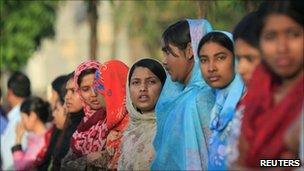 Employees of Grameen Bank form a human chain in front of their central office