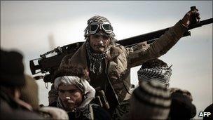 A Libyan rebel fighter stands by a machine gun at a check point in Brega