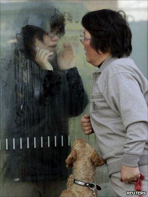 Mother tries to talk to her daughter who has been isolated for signs of radiation