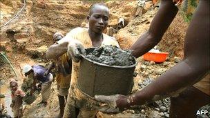 Miner passing a bucket in DRC