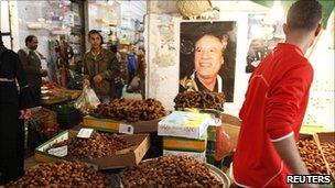 Portraits of Libya's leader Muammar Gaddafi adorn a date seller's stand at a market in the old town of Tripoli on Tuesday