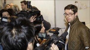 An unidentified bidder, representing an anonymous buyer, faces the cameras after securing the dress