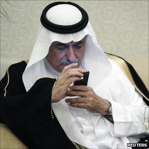 Saudi Arabia's Finance Minister Ibrahim al-Assaf looks at his iPhone during a financial conference in Riyadh