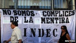 People walk by a banner that reads "We are not accomplices of the lie" placed by union workers outside Argentina's INDEC statistics agency in Buenos Aires, 2March, 2011