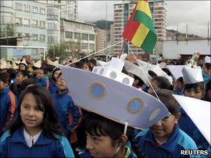 Bolivian children parading on the "Day of the Sea" with paper hats shaped like ships