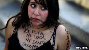 A woman pretends to be gagged during protests in Mexico City against the murder of women, 8 March 2011