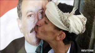 A supporter of President Saleh kisses a poster of him during a rally to show support at the Tahrir Square in Sanaa March 25, 2011