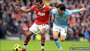 Manchester United's midfielder Nani (L) tussles with Manchester City's midfielder David Silva (R)