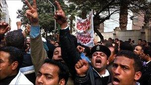 Angry crowd of police officers, some in uniform, in central Cairo.