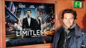 Bradley Cooper beside the Limitless poster