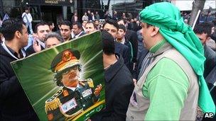 Members of pro-Islamic groups with a poster of Libyan leader Muammar Gaddafi, attend a protest against foreign intervention in Libya outside the US embassy in Ankara, Turkey, 27 March 27 2011