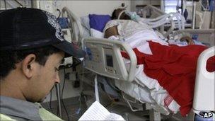 A relative reads a prayer book near an injured protester, 15 March