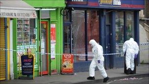 Forensic officers examine the scene in Brixton, south east London where a five year old girl was shot