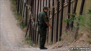 US border patrol agent at the US-Mexico border fence