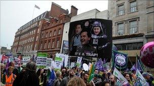 Anti-cuts protesters holding up placards.