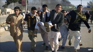 People carry an injured person in Mazar-e Sharif, Afghanistan (1 April 20110