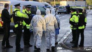 Forensic officers walk from the scene of a bomb that killed a Northern Ireland Police Officer