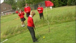 School children playing golf