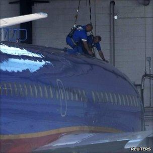 Mechanics work on a Southwest Airlines Boeing 737 at the Phoenix Sky Harbor International Airport in Phoenix, Arizona (2 April 2011)