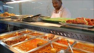 Worker serving food in Malaysian restaurant