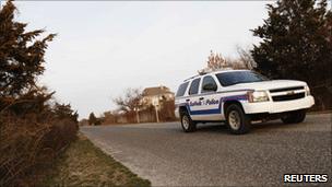 A Suffolk County, New York police car drives down Oak Beach