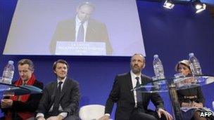 Participants in the debate on secularity listen to UMP leader Jean-Francois Cope (on screen) speaking in Paris, 5 April