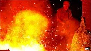 A steel worker works in front of giant iron melting pot in Kardemir Iron and Steel Factory in Karabuk