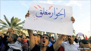 Protestor holds a sign in Pearl Roundabout