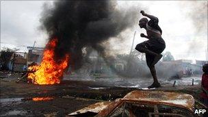 Man jumps on a burnt vehicle in Nairobi, Kenya, on 16/1/2008, during unrest that followed the disputed 2007 election