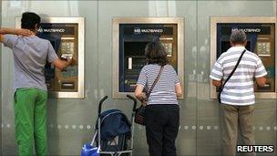 People using ATMs in Lisbon