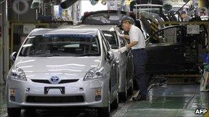 A factory worker checking an assembled car