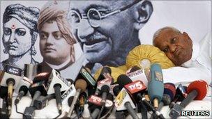 Social activist Anna Hazare rests near microphones of news channels during a "fast unto death" campaign in New Delhi April 8, 2011.