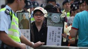 A woman holds banners denouncing China's government and the detention of mainland dissidents, during a protest outside the Chinese liaison office in Hong Kong on April 3, 2011