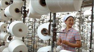 A woman works at a weaving factory