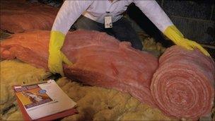 man insulating in attic area