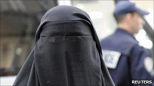 A woman in a veil outside a French police station