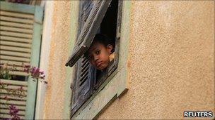 A Libyan child looks out of the window in Tripoli, 6 April 2011