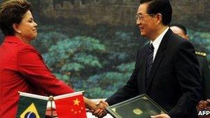 Brazilian President Dilma Rousseff shakes hands with her Chinese counterpart Hu Jintao