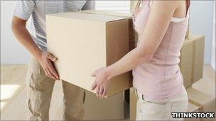 Couple carrying cardboard boxes