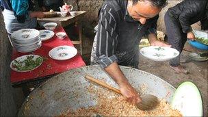 A man prepares pilaw ahead of the wedding